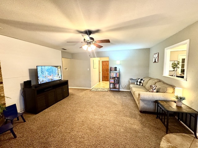 living area featuring visible vents, baseboards, carpet flooring, a textured ceiling, and a ceiling fan