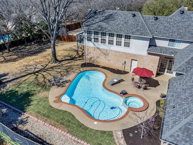 view of swimming pool with a patio, a fenced backyard, and a pool with connected hot tub