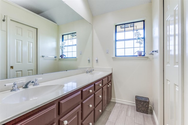 bathroom with a wealth of natural light, baseboards, and a sink