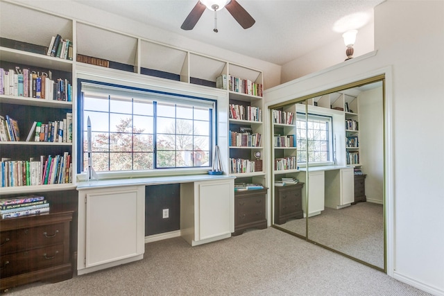 office area featuring light carpet, baseboards, a ceiling fan, and vaulted ceiling