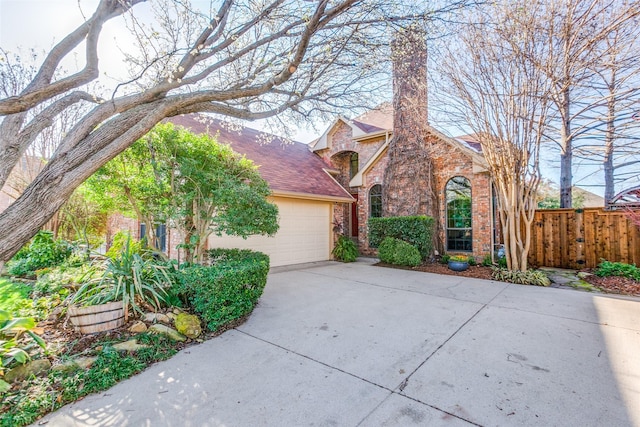 view of front of house featuring fence, driveway, an attached garage, a shingled roof, and brick siding