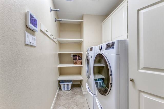 laundry area with cabinet space, light tile patterned floors, washer and dryer, and baseboards