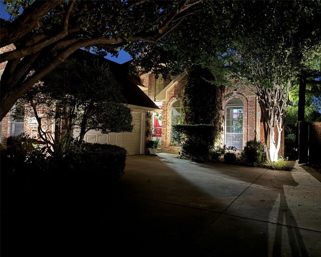 view of side of property with brick siding and concrete driveway