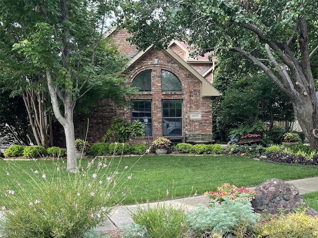 view of front of home featuring brick siding and a front lawn