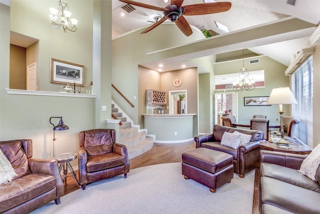 living room featuring stairway, wood finished floors, baseboards, visible vents, and high vaulted ceiling