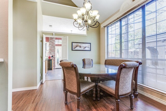 dining room with a notable chandelier, baseboards, and wood finished floors