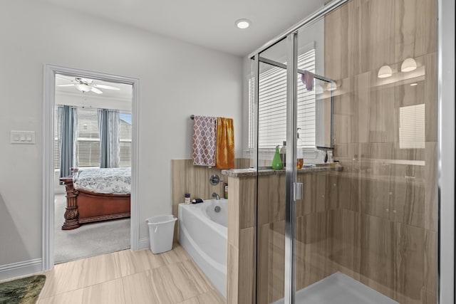 ensuite bathroom with a shower stall, a garden tub, baseboards, and connected bathroom