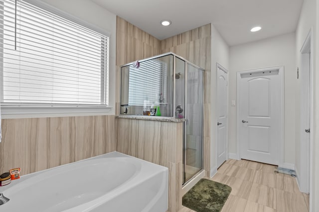 full bathroom with a shower stall, a bath, and recessed lighting