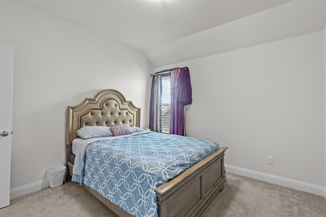 bedroom featuring lofted ceiling, baseboards, and carpet floors