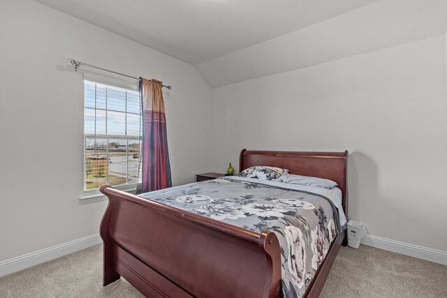 bedroom with baseboards, lofted ceiling, and carpet floors