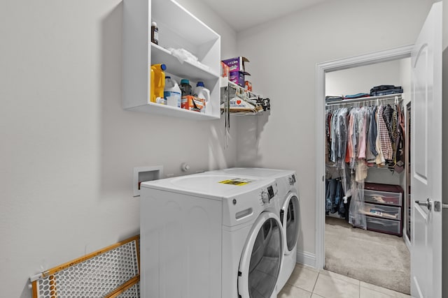 laundry area with baseboards, light carpet, laundry area, light tile patterned flooring, and independent washer and dryer