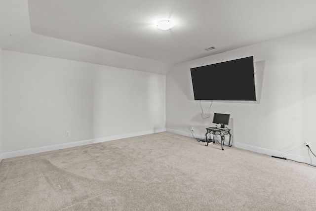 interior space with visible vents, baseboards, lofted ceiling, and carpet flooring