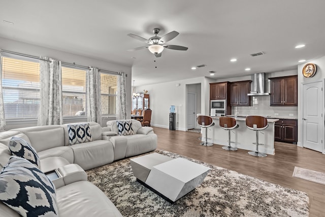 living area with visible vents, recessed lighting, a ceiling fan, and wood finished floors