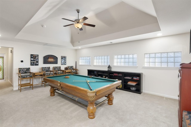 recreation room with light colored carpet, a raised ceiling, and baseboards