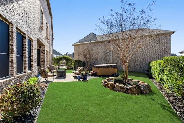 view of yard with a patio area, fence, a fire pit, and a hot tub