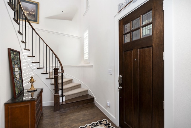 foyer featuring stairs, baseboards, and dark wood-style flooring