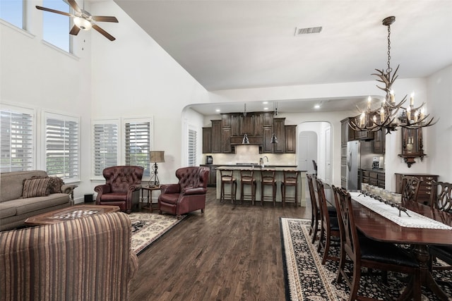 living area featuring visible vents, dark wood finished floors, recessed lighting, arched walkways, and ceiling fan