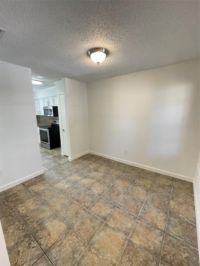 unfurnished room with a textured ceiling and baseboards