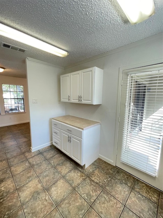 clothes washing area featuring visible vents, baseboards, and a textured ceiling