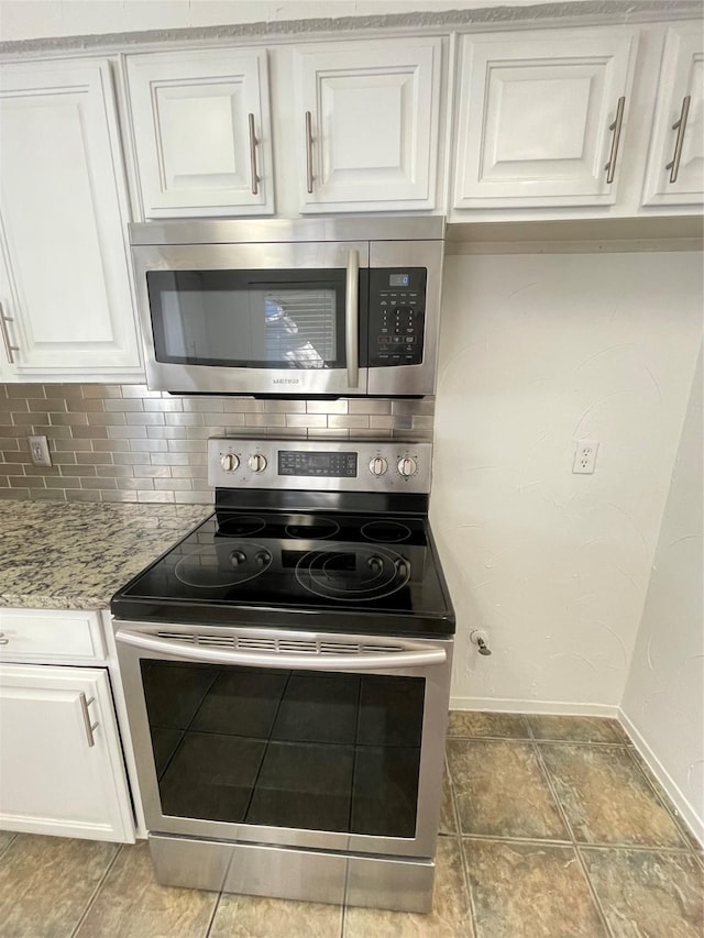 kitchen with white cabinets, light stone counters, tasteful backsplash, and stainless steel appliances