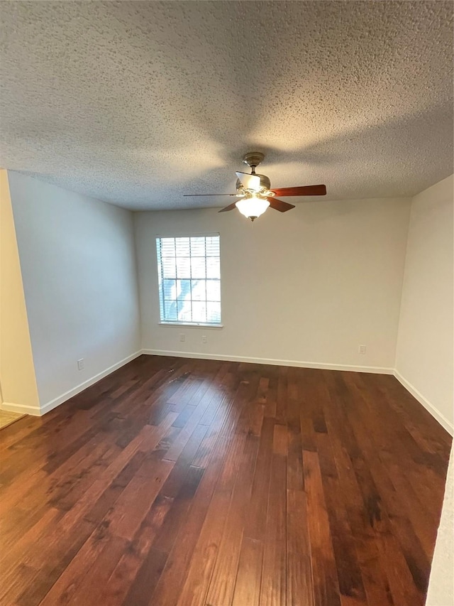 spare room with dark wood finished floors, baseboards, and a textured ceiling