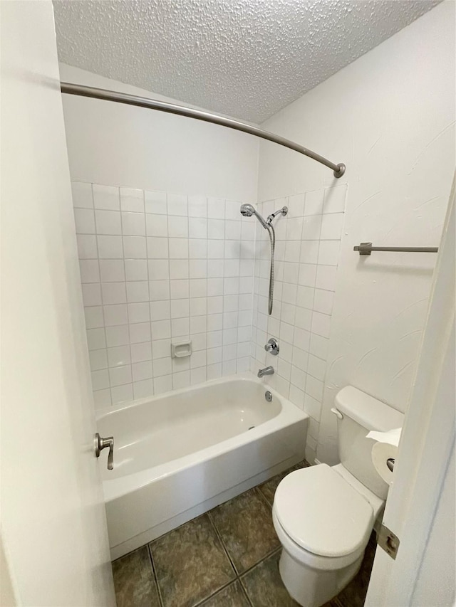 full bathroom featuring bathing tub / shower combination, a textured ceiling, tile patterned flooring, and toilet