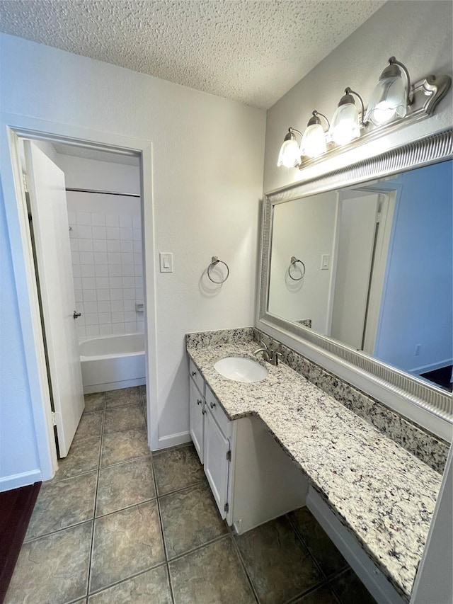 bathroom featuring tile patterned flooring, baseboards, shower / washtub combination, vanity, and a textured ceiling