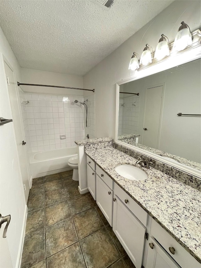 full bath featuring tile patterned floors, toilet, shower / tub combination, a textured ceiling, and vanity