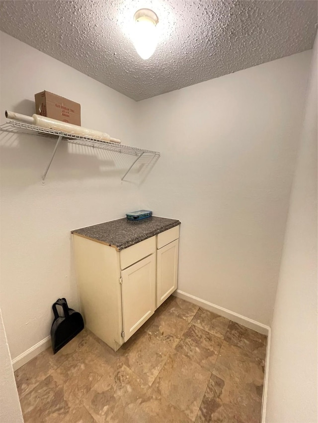 washroom featuring baseboards and a textured ceiling