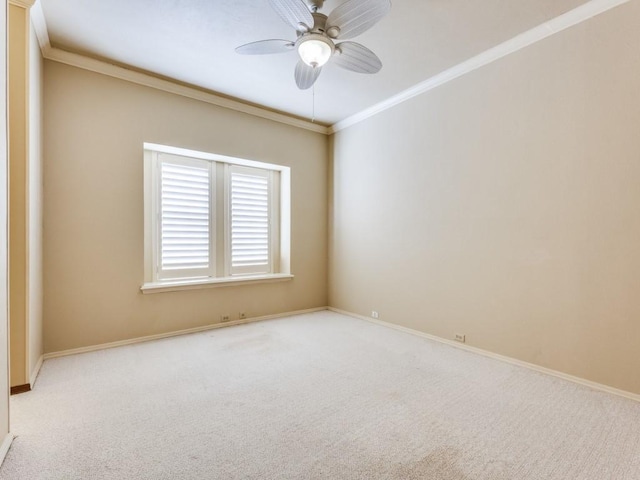 unfurnished room with crown molding, carpet, baseboards, and ceiling fan