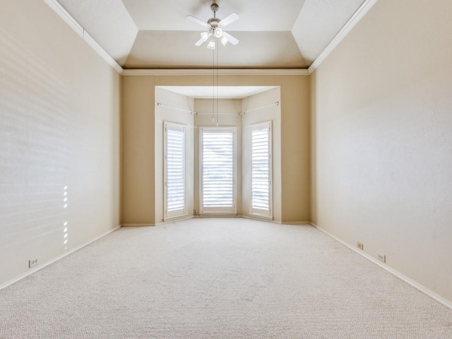 unfurnished room featuring a ceiling fan, lofted ceiling, a tray ceiling, carpet, and ornamental molding