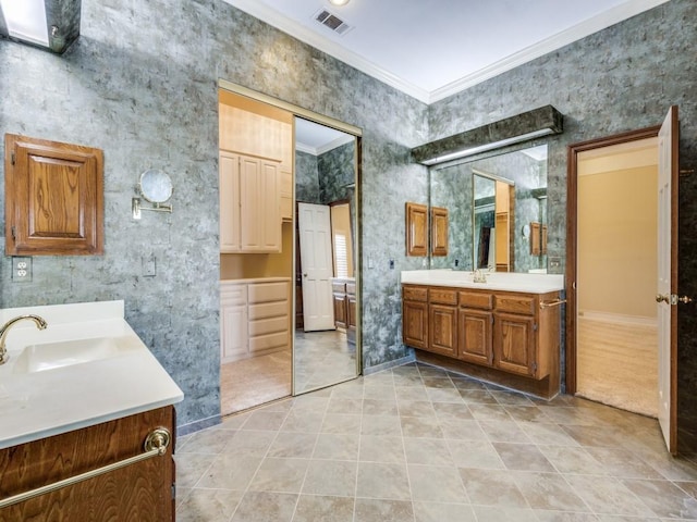 bathroom with visible vents, a sink, tile patterned flooring, two vanities, and crown molding