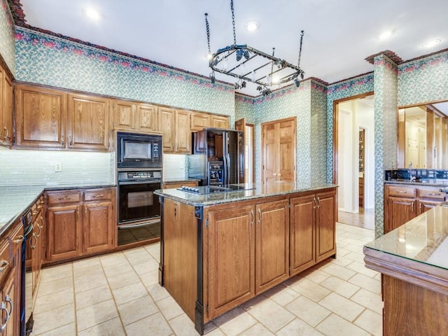 kitchen with stone countertops, wallpapered walls, a warming drawer, backsplash, and black appliances