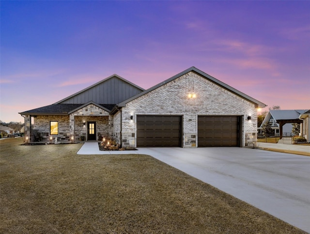 view of front facade with brick siding, a garage, and driveway