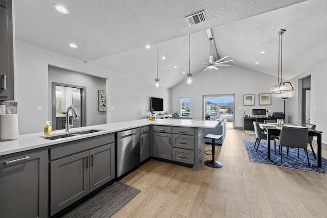 kitchen with visible vents, gray cabinetry, a sink, stainless steel dishwasher, and open floor plan