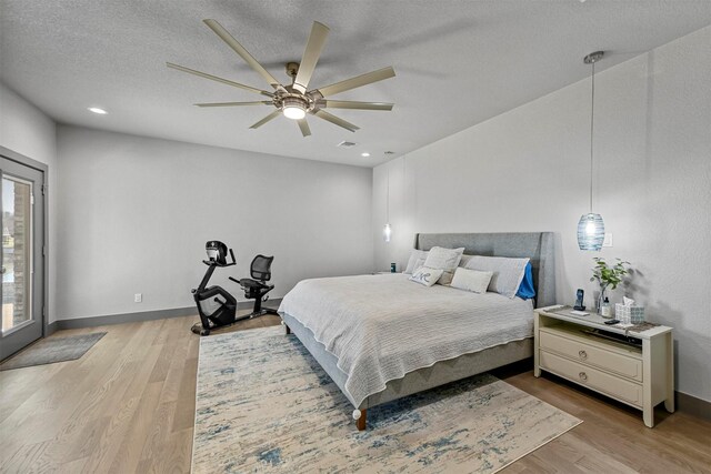 bedroom with baseboards, a textured ceiling, ceiling fan, and light wood finished floors