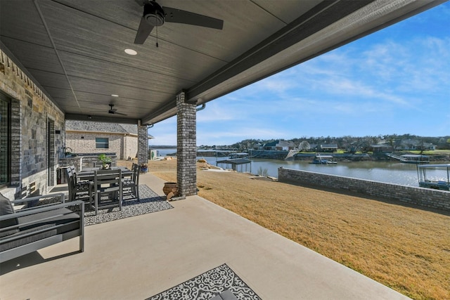 view of patio featuring outdoor dining area, a ceiling fan, and a water view