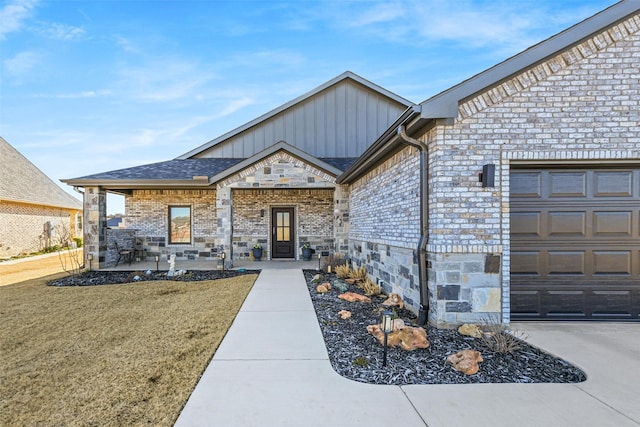 property entrance featuring brick siding, a lawn, board and batten siding, and a garage