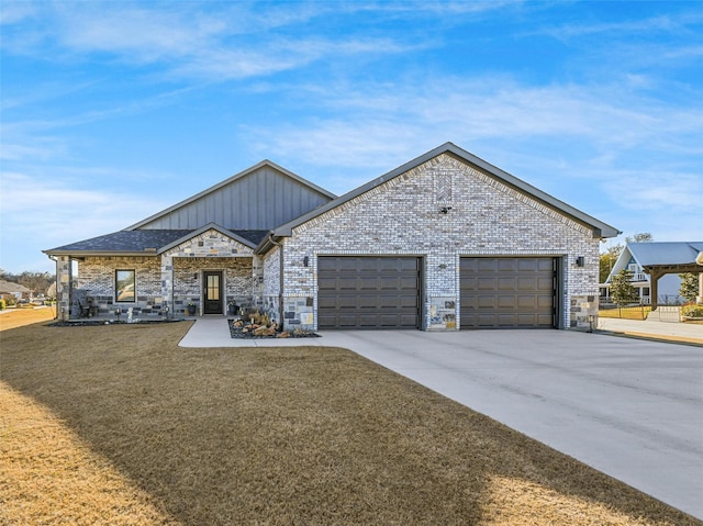 view of front facade with board and batten siding, brick siding, a garage, and driveway