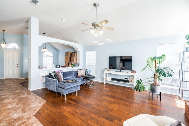 living area with visible vents, baseboards, lofted ceiling, hardwood / wood-style flooring, and a ceiling fan