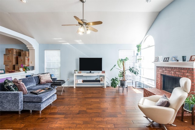 living area with lofted ceiling, a brick fireplace, and wood finished floors