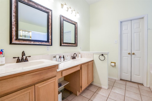 bathroom featuring tile patterned flooring, double vanity, and a sink