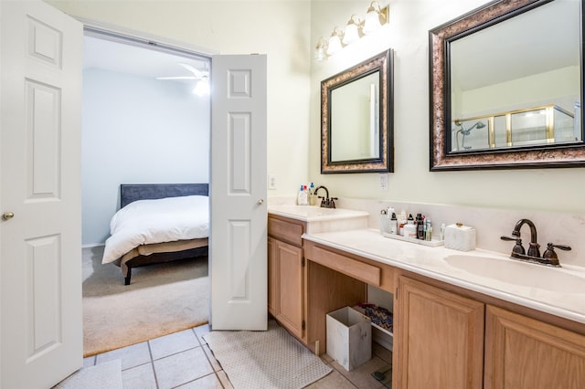 ensuite bathroom featuring tile patterned floors, double vanity, a shower with shower door, and a sink