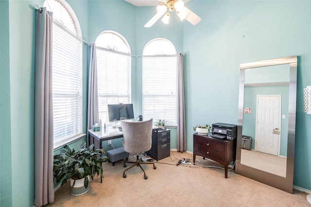 carpeted office space featuring a ceiling fan