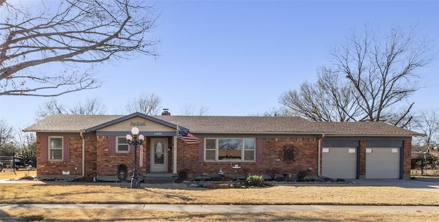 single story home featuring a garage, driveway, crawl space, brick siding, and a chimney