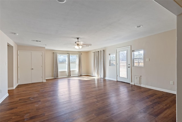 unfurnished living room featuring visible vents, baseboards, and dark wood-style flooring