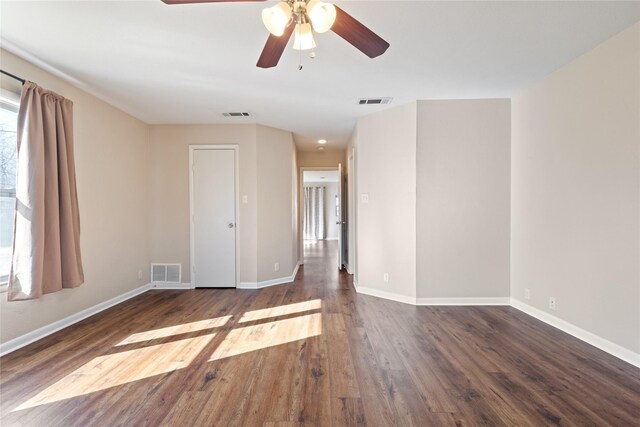 unfurnished room featuring ceiling fan, wood finished floors, visible vents, and baseboards