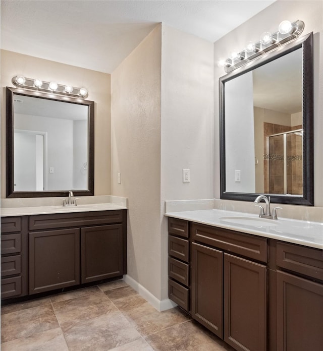 bathroom featuring two vanities, a stall shower, and a sink