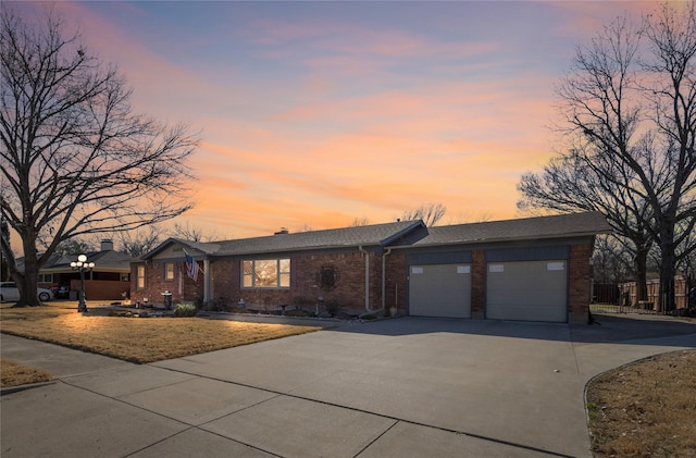 view of front of house with a garage, brick siding, and driveway