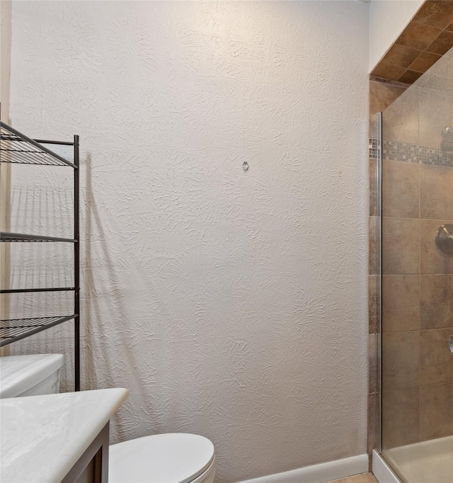 full bathroom featuring a shower stall, toilet, vanity, and a textured wall